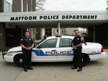 Two police officers standing in front of a police vehicle