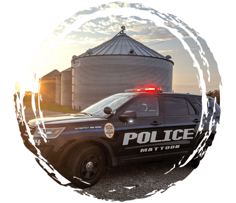 Police cruiser parked in front of grain bins with sun rising in the sky.